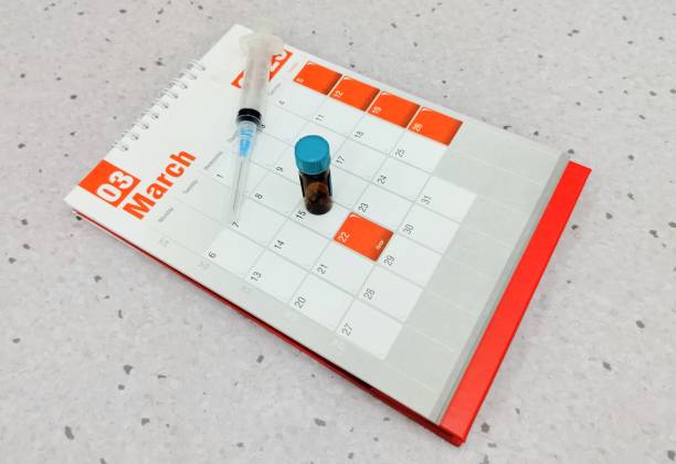 Vaccine vial and syringe placed on a 2026 chick vaccination calendar