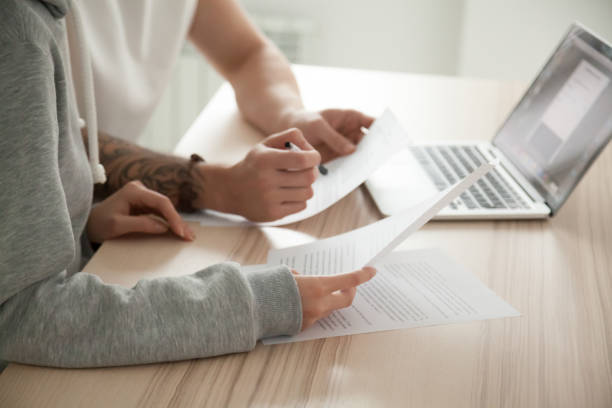 Employees reviewing documents and animal product information on a laptop
