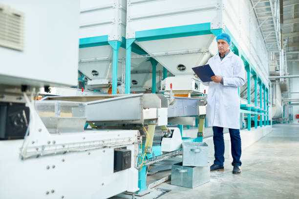 Nhân viên kiểm tra dây chuyền sản xuất thức ăn chăn nuôi tại nhà máy