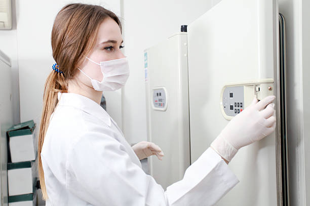 Nhân viên phòng thí nghiệm kiểm tra bảng điều khiển của tủ bảo quản vaccine